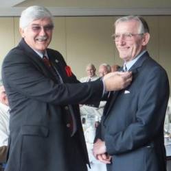 President David Knight pins the membership badge onto the lapel of new member Peter Valentine